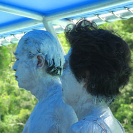 Japanische Touristen mit Ganzkörper-Schlamm-Peeling.