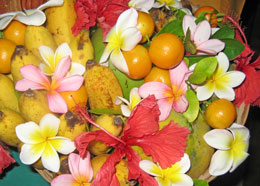 Korb mit exotischen Früchten und Blumen.